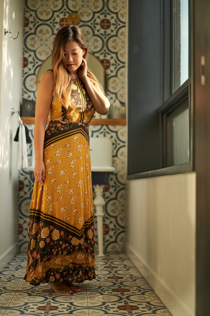 A tapestry of lines, like acupuncture channels, each interconnecting with others: woman wearing floral dress standing near window.