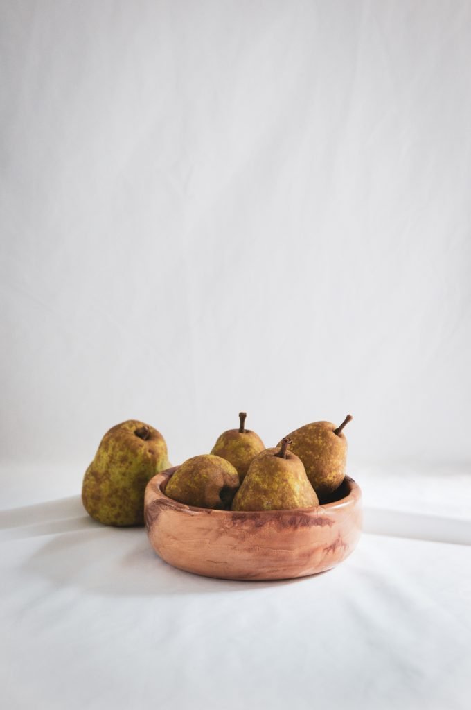 five pears fruit on brown wooden bowl