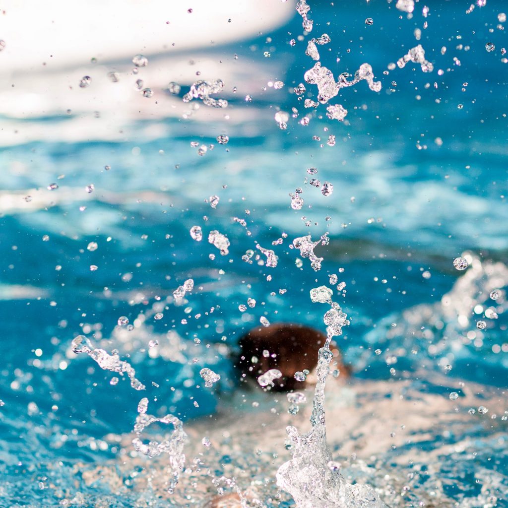 person diving on pool splashing water