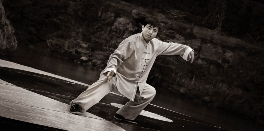 tai chi and ming men: man in white robe sitting on wooden dock
