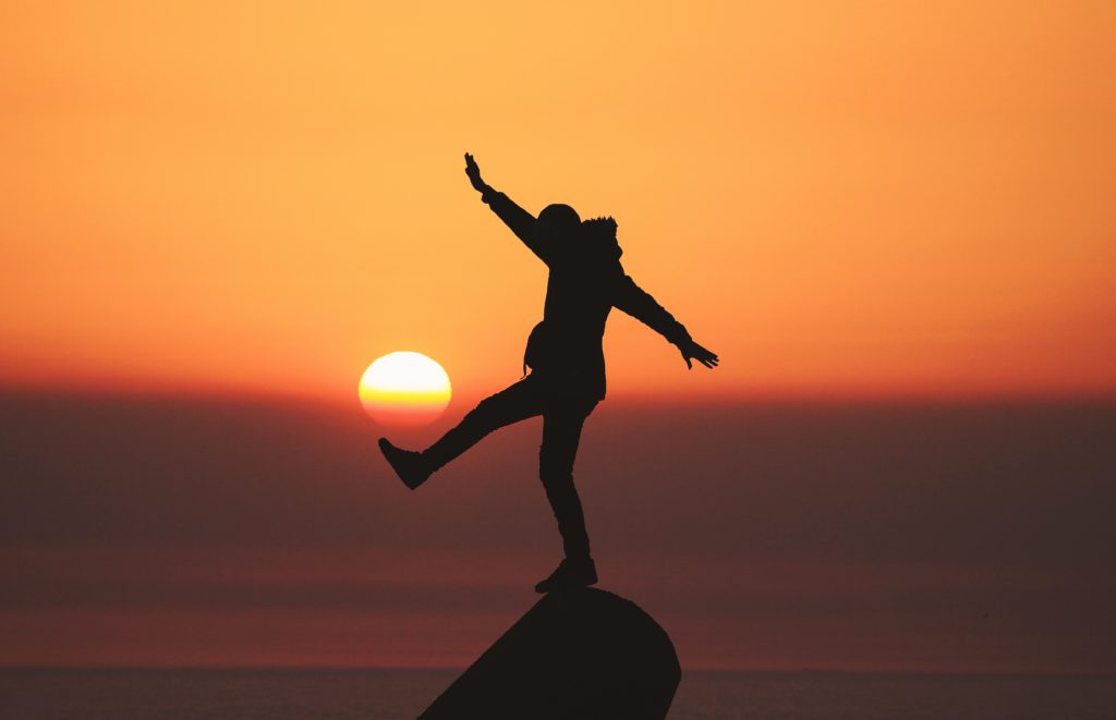 Balancing Cold with Hot foods - photo of silhouette photo of man standing on rock
