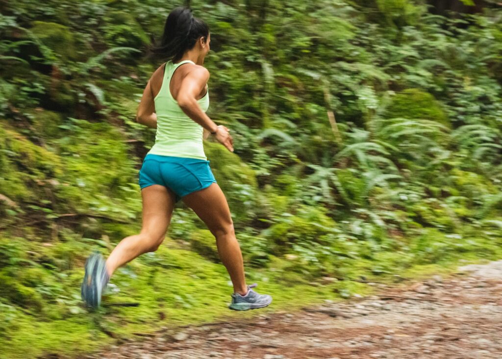 woman in white tank top running on dirt road during daytime - running creates heat that dries white phlegm colour