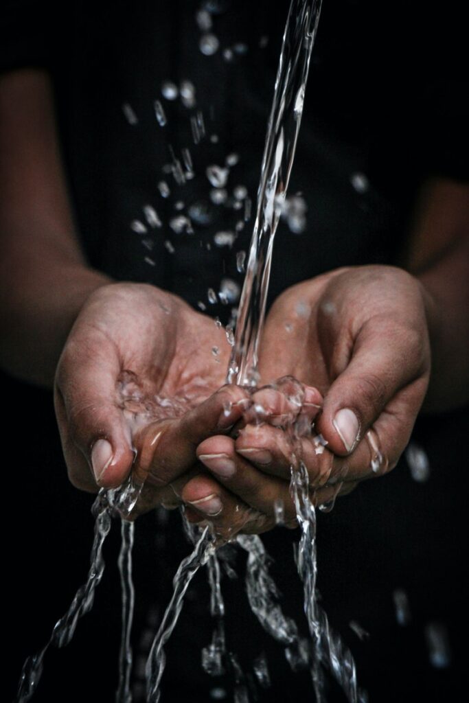 pouring water on person's hands. Tap water is often good enough for dry skin.
