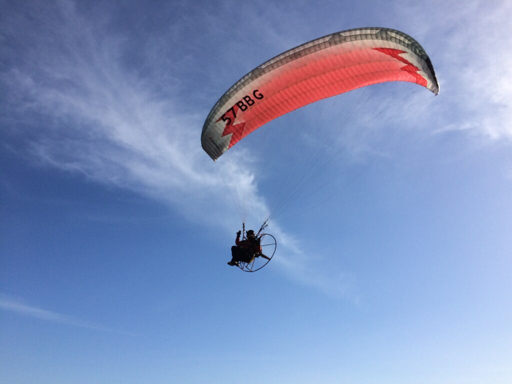 person paragliding under blue sky