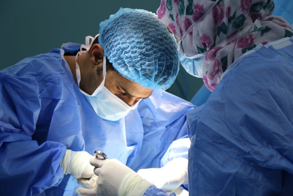 Surgeon operating eg for male infertility